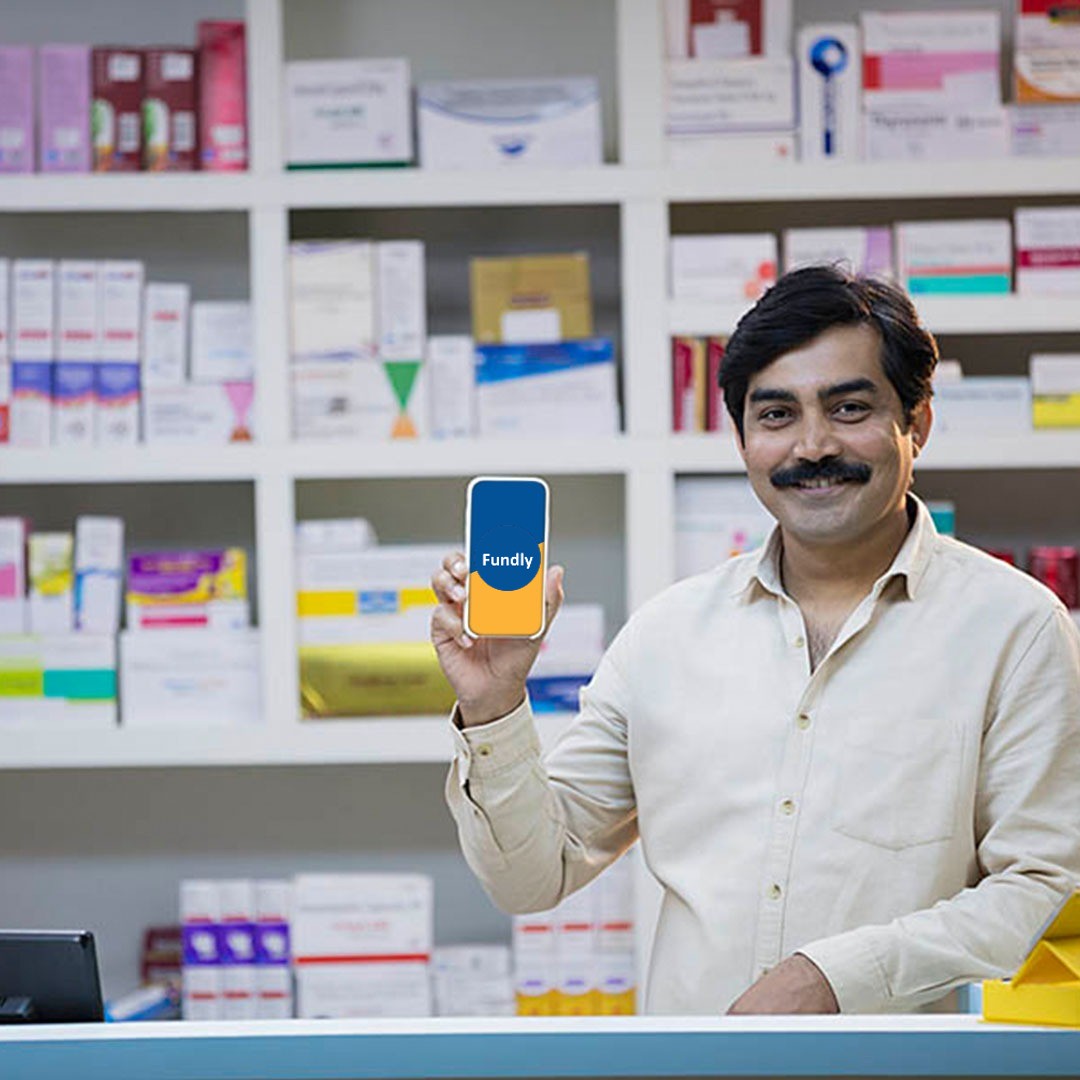 Picture of a man in a store holding a phone with fundly app